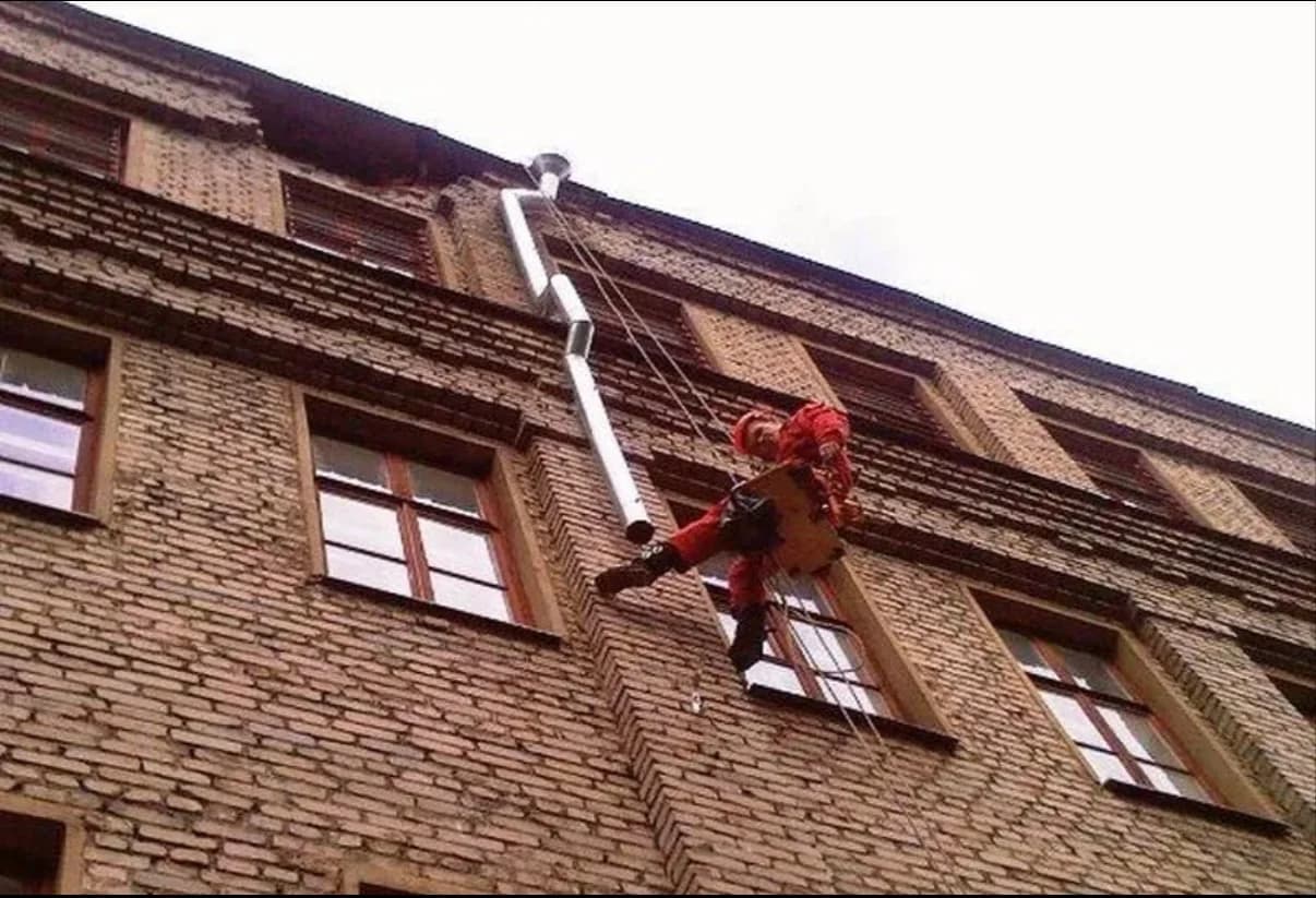 Монтаж водосточной системы промышленным альпинистом на фасаде здания