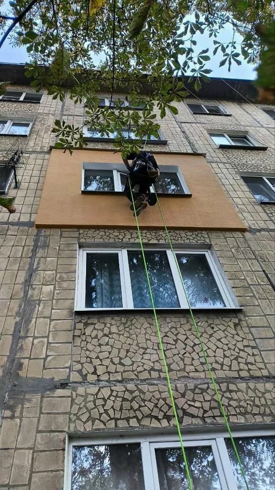 Специалист выполняет фасадные работы с применением канатного доступа